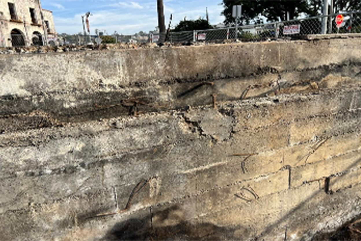 Close-up of a fire-damaged stem wall: cracks and discoloration consistent with elevated-temperature exposure.